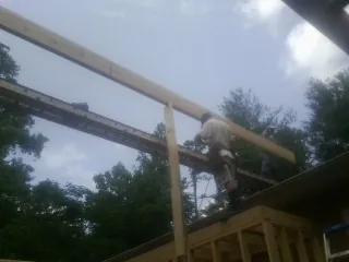 Carpenter setting a ridge beam over a new addition frame — Ice Dam Removal by Roofing Brothers in Fremont Center