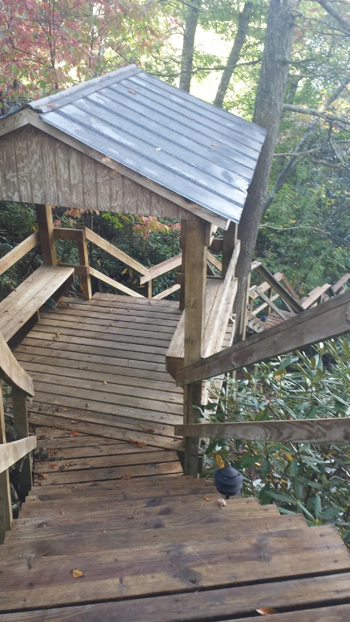 Metal roofed shelter over wooden steps on a wooded walkway — Skylight Repair & Installation work by our crew in Fremont Center
