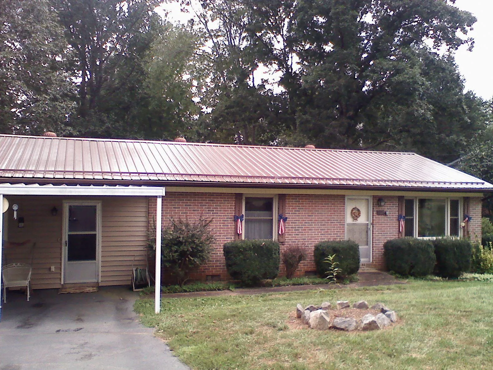 Bronze metal roof and carport on a brick ranch home — Roof Repair work by our crew in Fremont Center